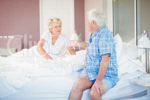 Senior couple talking in bedroom