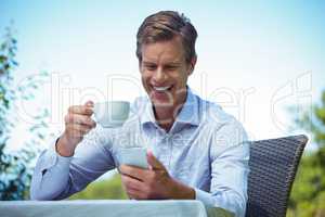 Businessman using smartphone with coffee