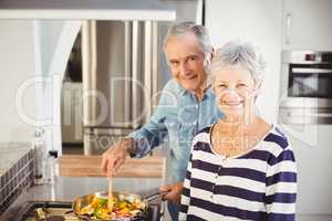 Portrait of senior couple cooking food