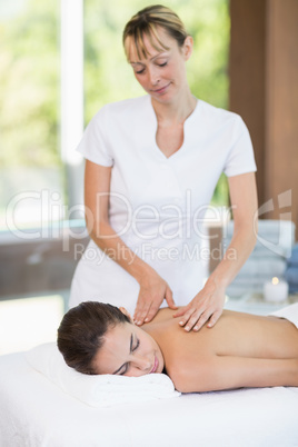 Female masseur massaging young woman