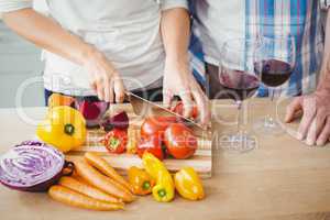 Cropped image of woman cutting tomatoes with husband