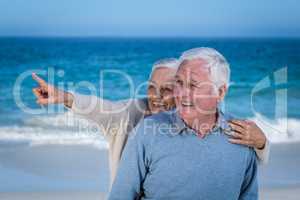 Senior couple embracing and pointing