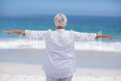 Rear view of mature woman posing with outstretched arms