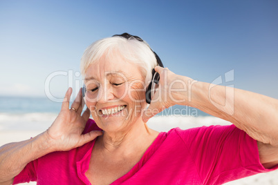 Senior woman listening music with headphone