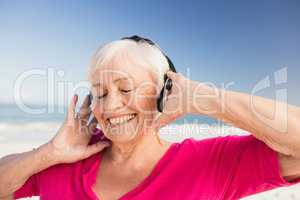 Senior woman listening music with headphone