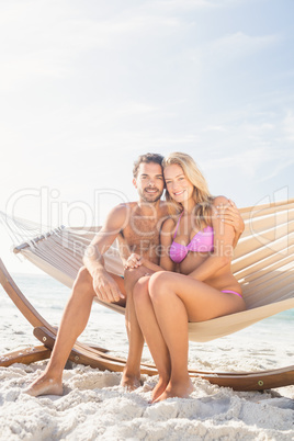 Smiling couple sitting in hammock