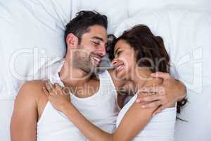 High angle view of happy couple relaxing on bed