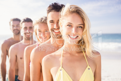 Smiling friends standing in line