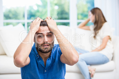 Upset man with hands on head after argument with wife