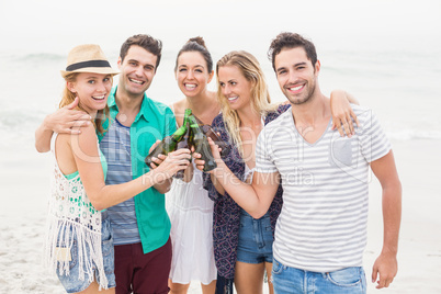 Group of friends toasting beer bottles on the beach