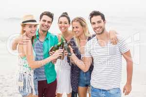 Group of friends toasting beer bottles on the beach