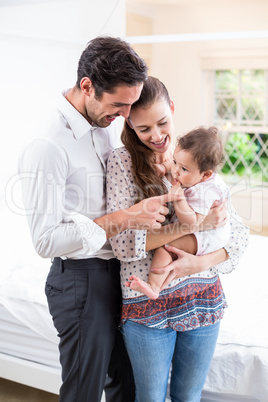 Smiling parents playing with baby