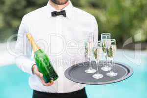 Waiter holding champagne flutes and bottle
