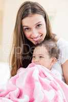 Portrait of smiling mother and baby with blanket