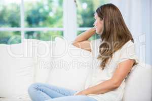Depressed woman sitting on sofa after argument with partner