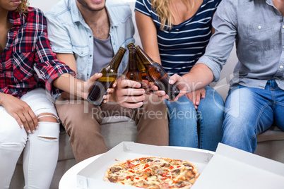 Friends enjoying beer and pizza at home