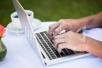 Casual businessman using laptop and having coffee