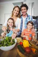 Portrait of happy parents with children in kitchen