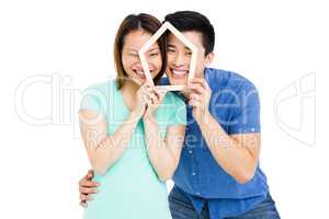 Young couple holding house shaped popsicle sticks