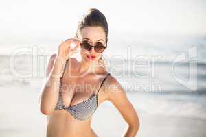 Portrait of glamorous woman in bikini standing on the beach