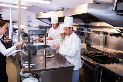 Group of chef preparing food in commercial kitchen