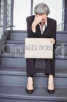 Unemployed businesswoman with need work placard