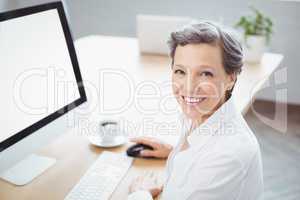 Happy businesswoman sitting at computer desk