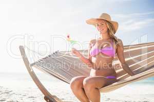 Woman drinking cocktail in hammock