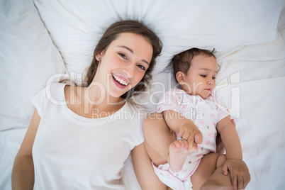 High angle view of happy woman lying with daughter High angle view of happy woman lying with daughter