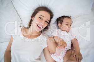 High angle view of happy woman lying with daughter