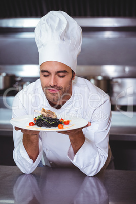 Male chef with eyes closed smelling food