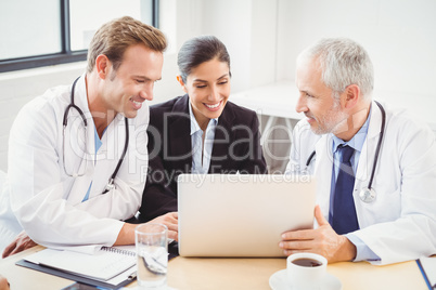 Medical team using laptop in conference room