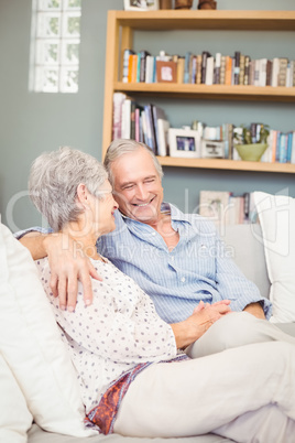 Happy romantic senior couple sitting on sofa