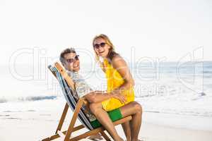 Woman sitting on mans lap at beach