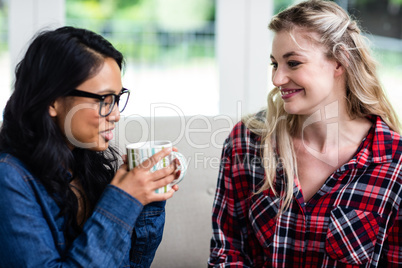 Close-up of young female friends drinking coffee