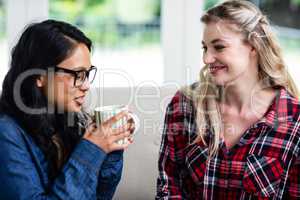 Close-up of young female friends drinking coffee