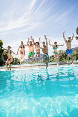 Group of friends jumping in swimming pool
