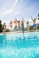 Group of friends jumping in swimming pool
