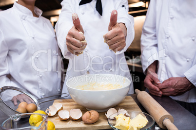 Head chef showing thumbs up while preparing dough