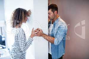 Upset couple standing on opposite sides of the wall