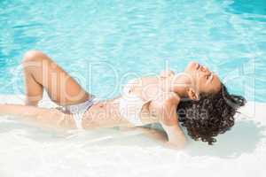 Beautiful woman relaxing by swimming poolside