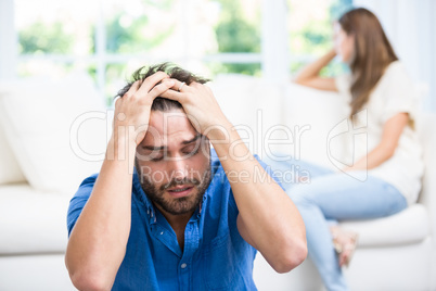 Tensed man sitting on floor after argument with wife
