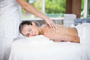 Woman receiving back massage from female masseur