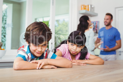 Children making faces while sitting at table