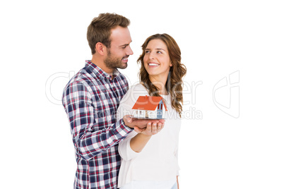 Happy young couple holding model house