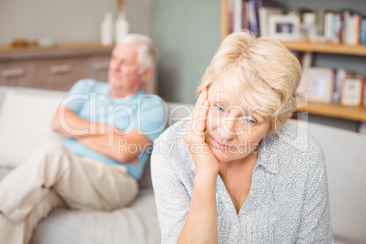 Tensed senior couple sitting on sofa