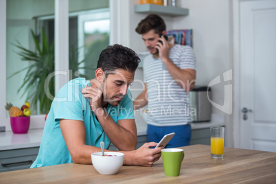 Tensed Man using phone at table