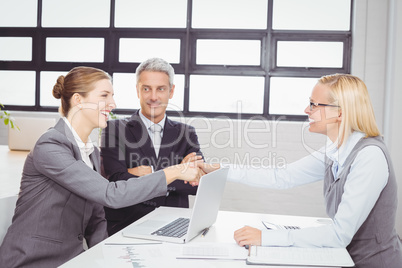Happy business people handshaking with client
