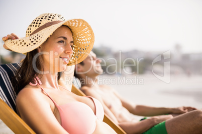 Young couple relaxing on armchair on the beach