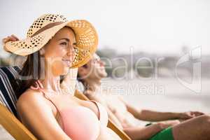 Young couple relaxing on armchair on the beach